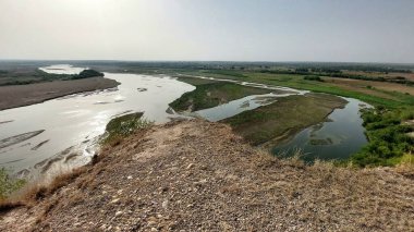 Punjab 'daki Sawan Nehri' nin güzel bir manzarası, etrafını çevreleyen tepeleri çevreleyen yemyeşil bitkiler ve çalılarla birden fazla kanaldan akan, huzurlu doğal bir manzara yaratıyor.