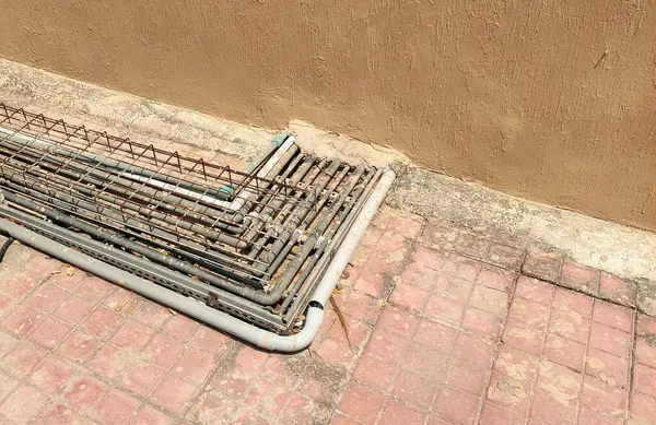 İçerideki ve dışarıdaki endüstriyel AC ünitelerini birbirine bağlayan organize bir ağ oluşturan sayısız boru ve kablo düzenli bir şekilde sıralanmıştır.