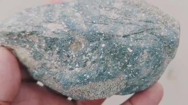 Karmaşık doğal desenlere, çizgilere, noktalara ve belirgin jeolojik oluşumunu vurgulayan çarpıcı renklere sahip eşsiz şekilli bir taş.