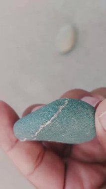 Karmaşık doğal desenlere, çizgilere, noktalara ve belirgin jeolojik oluşumunu vurgulayan çarpıcı renklere sahip eşsiz şekilli bir taş.
