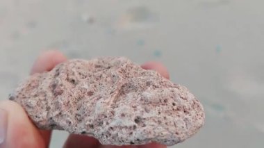 Karmaşık doğal desenlere, çizgilere, noktalara ve belirgin jeolojik oluşumunu vurgulayan çarpıcı renklere sahip eşsiz şekilli bir taş.