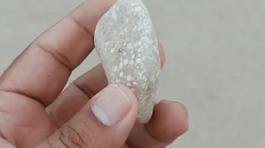 Karmaşık doğal desenlere, çizgilere, noktalara ve belirgin jeolojik oluşumunu vurgulayan çarpıcı renklere sahip eşsiz şekilli bir taş.
