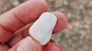 Karmaşık doğal desenlere, çizgilere, noktalara ve belirgin jeolojik oluşumunu vurgulayan çarpıcı renklere sahip eşsiz şekilli bir taş.