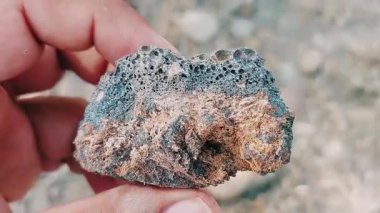 Karmaşık doğal desenlere, çizgilere, noktalara ve belirgin jeolojik oluşumunu vurgulayan çarpıcı renklere sahip eşsiz şekilli bir taş.