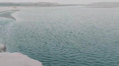 Şiddetli rüzgarları nehri süpüren hızlı hareket eden kum fırtınası su yüzeyinde kanat ve dalgalar oluşturarak dramatik ve güzel bir doğal manzara oluşturur.