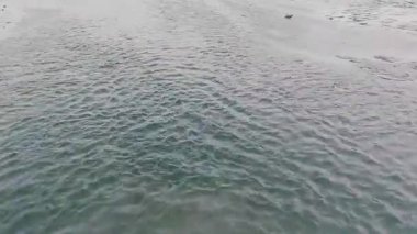 Şiddetli rüzgarları nehri süpüren hızlı hareket eden kum fırtınası su yüzeyinde kanat ve dalgalar oluşturarak dramatik ve güzel bir doğal manzara oluşturur.