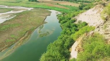 Punjab 'daki Sawan Nehri' nin güzel bir manzarası, etrafını çevreleyen tepeleri çevreleyen yemyeşil bitkiler ve çalılarla birden fazla kanaldan akan, huzurlu doğal bir manzara yaratıyor.