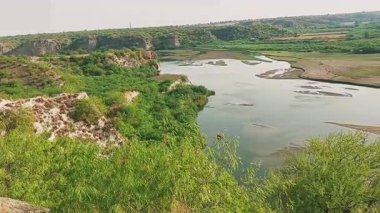 Punjab 'daki Sawan Nehri' nin güzel bir manzarası, etrafını çevreleyen tepeleri çevreleyen yemyeşil bitkiler ve çalılarla birden fazla kanaldan akan, huzurlu doğal bir manzara yaratıyor.