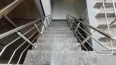 Çağdaş granit merdiven, bölünmüş iniş ve paslanmaz çelik parmaklıklar.