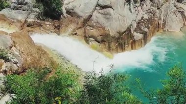 Magnificent cascading waterfall with golden sunlight and aquamarine natural pool view