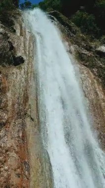 Dramatic upward view of Shambal waterfall cascading down rocky cliffs in Islamabad