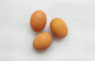 Açık gri arkaplanda izole edilmiş üç tavuk yumurtası..