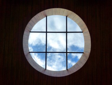 Circular lightwell from rumber ceiling rooftop as a main skylight showing sky above. With black metal framings and transparant glass panel. clipart