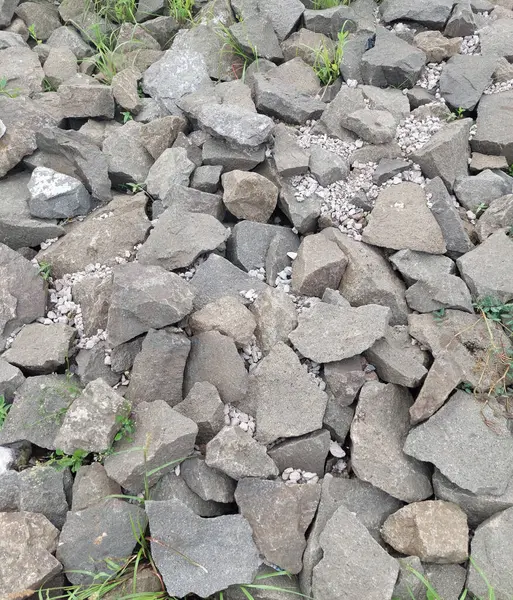 stock image Riverbank basecourse rock made of siltstone and cobblestone, mixed with split grey limestone mainly used to build dam, building or house base foundation, sloof, boulder and road surface.