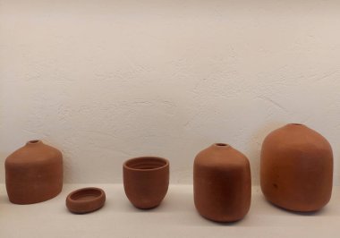 Stucco beyaz duvarında vazoları, aksesuarları ve gizli dolaylı ışıklarla diğer dekorasyon ve aksesuarları gösteren açık ekran yuvası 