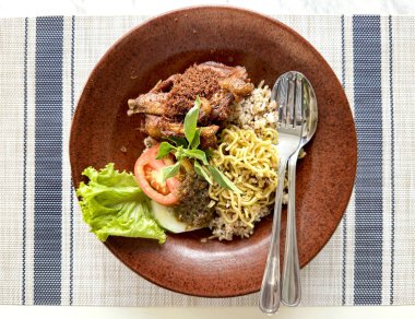 Traditional modern Indonesian food. Deep fried chicken with crisply herbs, served with noodle, fried sauted chili and Kecombrang  rice. This is one of Indonesian typical traditional food rich of herbs and spices. Served modernly. clipart