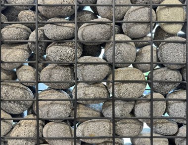 Close up photo of gabion wall, gabion is a series of riprap or rubbles stones, stacked and solidified and confined inside a wiremesh metal to function as a partition or retaining wall structure. clipart