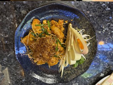 Pad Thai usulü tavuk. Pad Thai Tayland erişte ve yerel sostan yapılan ünlü bir ulusal yemektir..