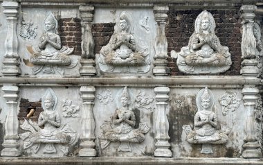 Tapınak rahatlaması ve beyaz taşlara yontulmuş, dışarıda çürüyen Buda hikayelerini tasvir eden oymaların detaylarını kapat..