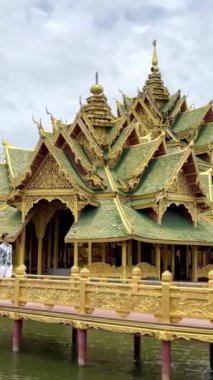 Asyalı bir adamın Muang boran Antik kenti Samut Prakan, Bangkok, Tayland 'daki yeşil tapınak kompleksi Aydınlanmış Pavilion' a doğru yürüdüğü görüntüler..