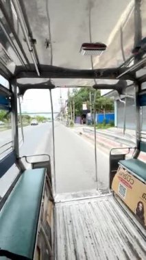 Tuktuk ve Songthaew 'in görüntüleri, Tayland' a özgü geleneksel bir ulaşım aracı. Videoda geleneksel Songthaew aracında otururken arabanın arkasındaki manzarayı görüyoruz..