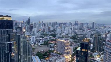 Bangkok 'un ufuk çizgisinin, Bangkok' un finans bölgesinin, gökdelenlerin ve binaların gün batımında gökdelenlerin görüntüsü. Bangkok Finansal Sukhumvit Bölgesi.