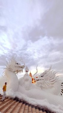 Wat Huay Pla Kang 'da merdivenlerden inen bir adamın görüntüsü, ya da Chiang Rai, Tayland' daki Merhamet Tapınağı. Guan Yin Buddha heykelinin ayağında büyük ejderha heykeli.