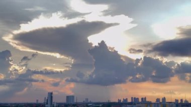 4K Şehri Panoramik Video. Gün batımının muhteşem manzarası mavi gökyüzü renklerinin güzel kombinasyonu, kor güneş ışıkları, ve şehrin üzerinde gökdelenleri gösteren birkaç eşsiz yüzen bulut..