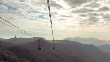 Hong Kong, Lantau Adası 'ndaki Ngong Ping 360 teleferiğinin nefes kesici görüntüsü. Günbatımı gökyüzünde çekilmiş bir video. Teleferikle ünlü tepeleri ve kırsal bölgeleri yukarıdan gören.