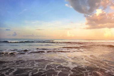 Endonezya, Bali 'de gün batımında güzel dalgalar ve alçak gelgitlerle, yaz meltemiyle birlikte gün batımını izlemek mükemmel bir tatil, romantik ve seyahat deneyimi için..