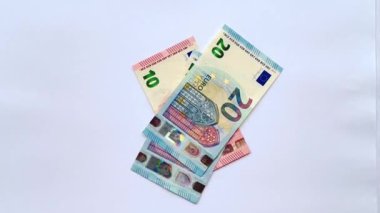 Euro banknotlarının 4K görüntüsü düşmüş, atılmış ve beyaz arka plana saçılmış. Euro 'nun nominal değeri 50 Euro' dan 20 Euro 'ya ve 10 Euro' ya kadar olan para banknotları sayılıyor. İzole edilmiş beyaz arkaplan.