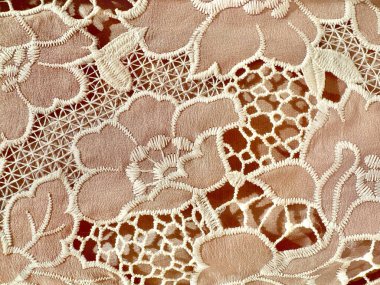 Çiçek deseninde dikilmiş pembe şeftali naylon kumaş kapağı. Süslü pileli ağlar ve yeşillik desenleri var. Çiçekli pembe kumaş dikişsiz arkaplan dokusu.