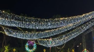 Noel dekorasyonunun 4K görüntüsü. LED pırıltı ya da sarkık ışıklar Noel çelengi ile şal ya da tinsel şeklinde şekillenir. Parlak ve etkileşimli.
