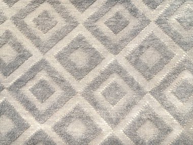 Close up of repetitive diamond shape fabric or carpet rug in grey and white color. Seamless background texture. clipart