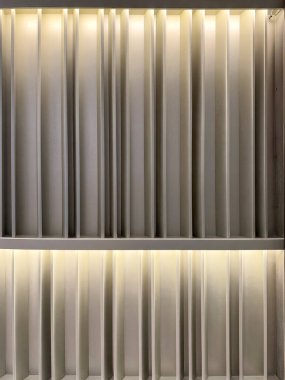 Close up of wood fluted panel with linear light washer. Wall panel 3D texture with fluted strips panel and led lights warm white seamless background texture.  clipart