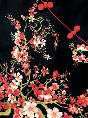 Kırmızı ve beyaz kiraz çiçeğinin dalları ve siyah arkaplanda yaprakları var. Geleneksel Çin kıyafetleri ya da Cheongsam. Kusursuz arkaplan dokusu.