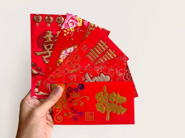 El ele tutuşan Çin kırmızı zarfları, Hongbao ya da angpao olarak da bilinir. Kırmızı zarf parayla dolu ve Çin 'deki evlilik bağıyla ünlüdür. Çince Shuang Xi kelimesi çifte mutluluk anlamına gelir..