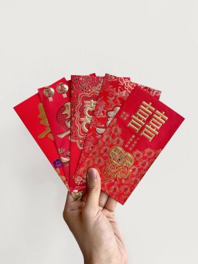 El ele tutuşan Çin kırmızı zarfları, Hongbao ya da angpao olarak da bilinir. Kırmızı zarf parayla dolu ve Çin 'deki evlilik bağıyla ünlüdür. Çince Shuang Xi kelimesi çifte mutluluk anlamına gelir..