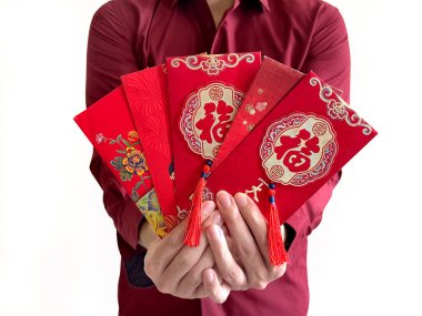 Elinde Çin kırmızı zarfları olan Asyalı bir adam. Hongbao ya da angpao olarak da bilinir. Kırmızı zarf parayla dolu ve Çin Yeni Yılı 'yla ünlüdür. Çince 'de Fu, Lütuf anlamına gelir. Beyaz arkaplanda.