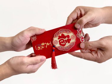 İki el Çin 'e kırmızı zarf veriyor. Hongbao ya da angpao olarak da bilinir. Parayla dolu ve Çin Yeni Yılı 'yla ünlü. Çince 'de Fu, Lütuf anlamına gelir. Beyaz arkaplanda.