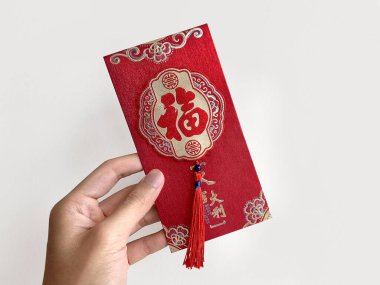 El ele tutuşan Çin kırmızı zarfı, Hongbao ya da angpao olarak da bilinir. Bu kırmızı zarf parayla dolu ve Çin ya da Ay Yeni Yılı ile ünlüdür. Çince 'de 