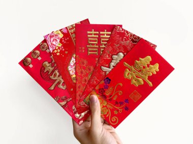 El ele tutuşan Çin kırmızı zarfları, Hongbao ya da angpao olarak da bilinir. Kırmızı zarf parayla dolu ve Çin 'deki evlilik bağıyla ünlüdür. Çince Shuang Xi kelimesi çifte mutluluk anlamına gelir..