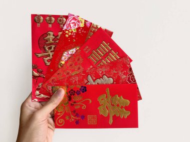 El ele tutuşan Çin kırmızı zarfları, Hongbao ya da angpao olarak da bilinir. Kırmızı zarf parayla dolu ve Çin 'deki evlilik bağıyla ünlüdür. Çince Shuang Xi kelimesi çifte mutluluk anlamına gelir..