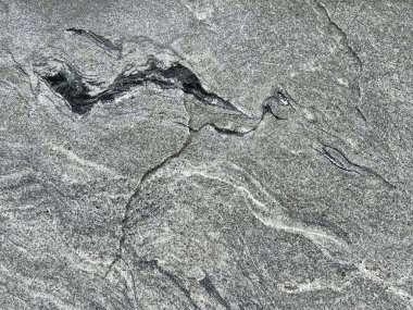 Rastgele siyah damarları ve üç boyutlu dokusu olan doğal gri taş graniti kapat. Dev gri ve siyah granit levha, duvar kaplamalarına uygun doğal taş deseni. Kusursuz arkaplan dokusu