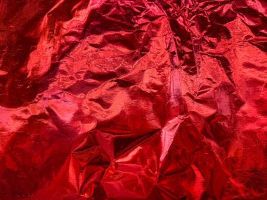 Koyu kırmızı kağıt dokusunun yakın fotoğrafını çek. Kırışmış kırmızı kağıt, dikişsiz arkaplan dokusu. Parlak, saten ve parıltılı. Folyo deseni.