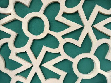 Ortadoğu süsleme desenli, yeşil arka planlı parlak altın çiçekli lazer yakın çekim. Geometrik duvar desenli dekorasyon paneli. Arap hissi. Kusursuz arkaplan dokusu.