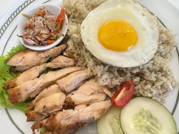 Limonlu pilav ya da limonlu pirinçli doğranmış kızarmış tavuğa yakın yumurta ve sambal matah. Sambal matah, Endonezya 'ya özgü kızarmış soğandır. Tavuk yemeği fotoğrafçılığı.