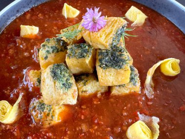 Koyu kırmızı soslu mapo tofu 'ya yakın çekim. Mapo tofu Güney Çin kökenli tipik bir Çin Hakka mutfağıdır. Gri bir tabakta, siyah bir mermer masada servis edildi..