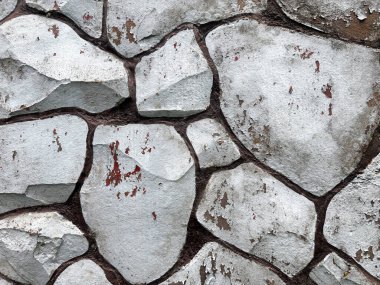 Rastgele kesilen açık gri ve beyaz çakıl taşlarının yüzeyde düzleştirilmesi. Döşeme ya da duvar işi bitsin diye rastgele ve beton kaplı sert kaldırım taşı ve çakıl yığını. Kusursuz arkaplan