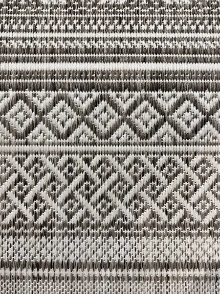 El yapımı geleneksel örülmüş halı dokusunu beyaz ve gri siyah renklerle kapatın. Şevron, elmas ve şerit desenli el örgüleriyle dikilmiş klasik halı kavramı. pürüzsüz arkaplan.